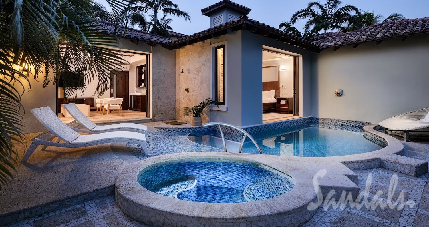 Private swim-out suite at dusk with a plunge pool, hot tub, and loungers just outside the room